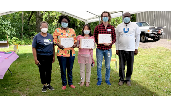 culturally diverse community clinic staff dressed in street clothes under tent outdoors